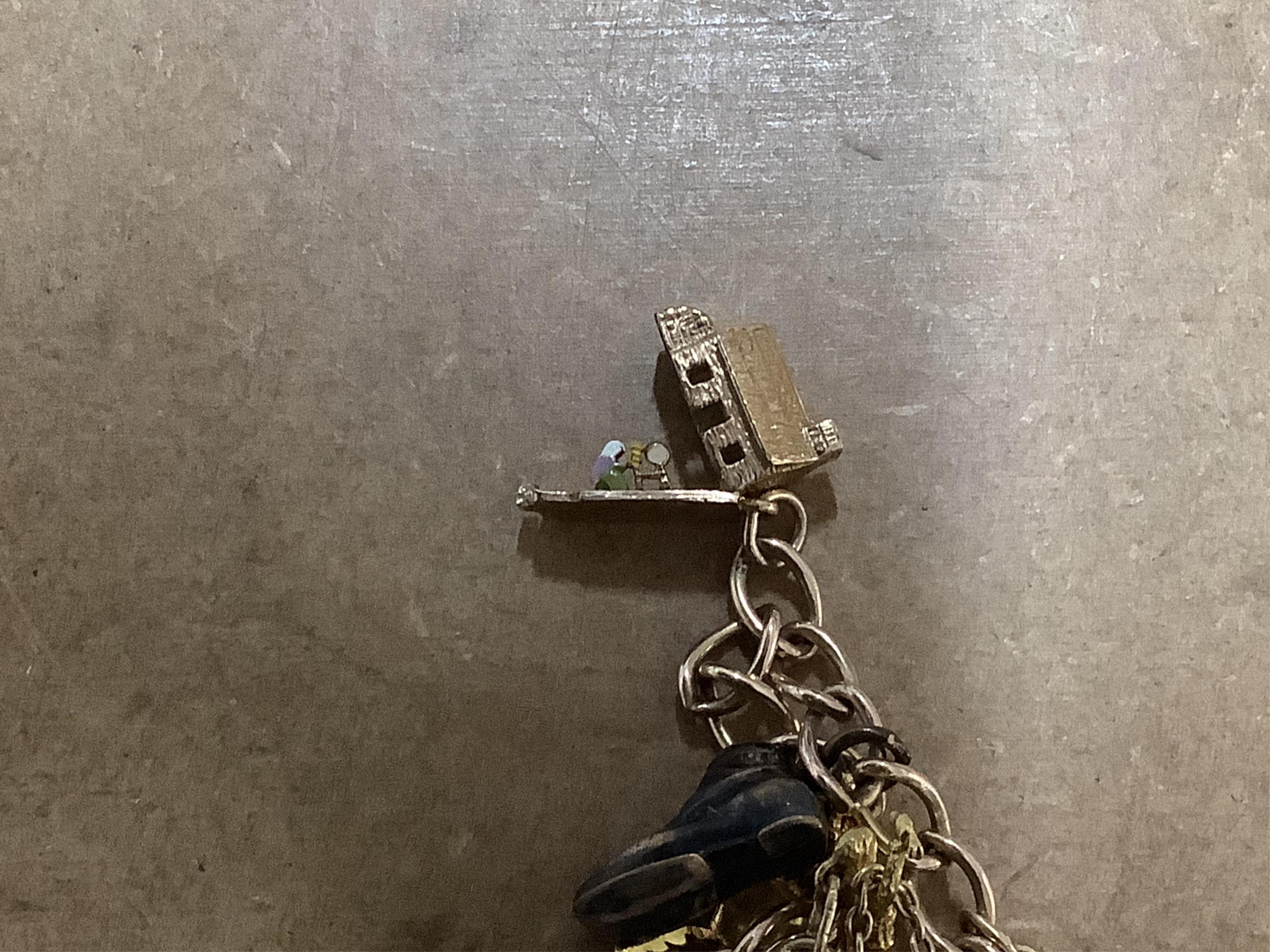 A 9ct gold curb link charm bracelet, hung with ten assorted 9ct gold and yellow metal charms including enamelled R.A.F. charm and a pixie on a toadstool, approximately 14cm, gross weight 31 grams.